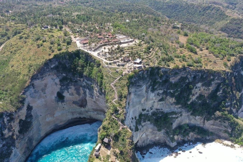 Aerial view of Raja Lima at the top of the cliffs, above the turquoise water of Diamond Beach and Atuh Beach
