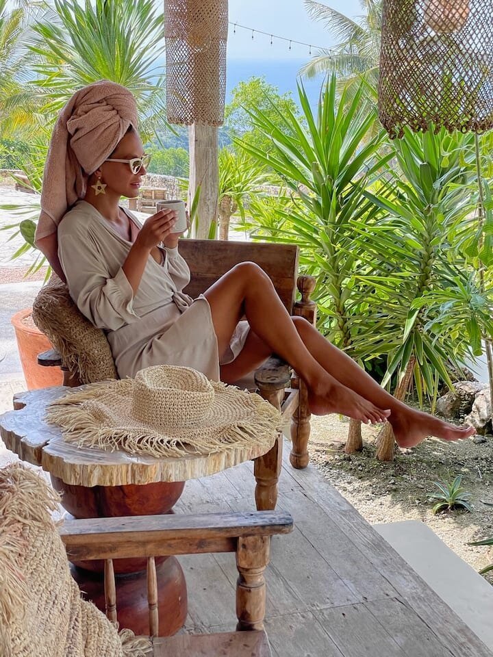A guest relaxing with a coffee on the terrace after a shower