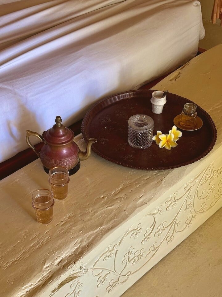 A tea tray with fresh frangipani beside the bed