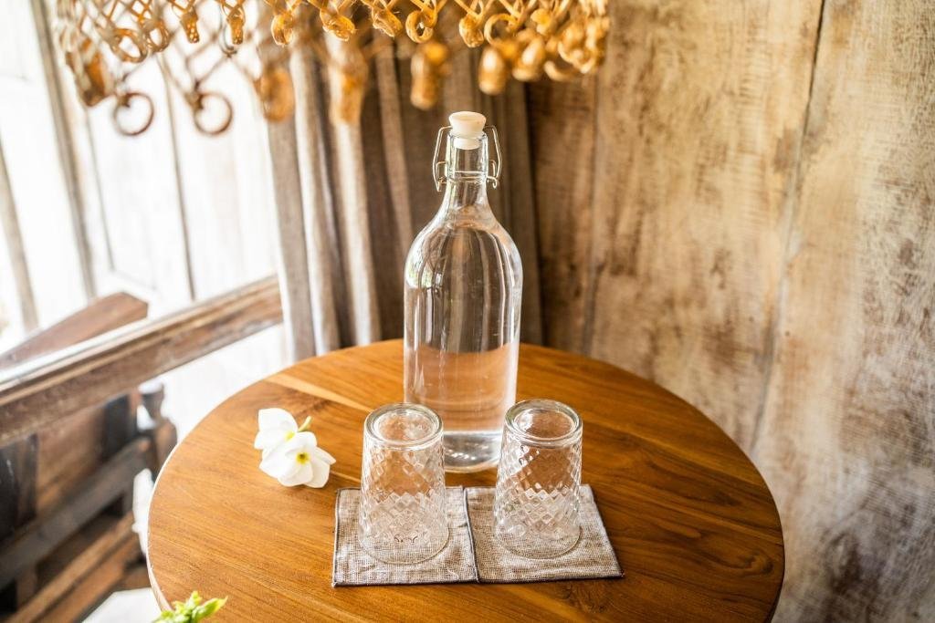 A carafe of water and glasses on a round wooden table