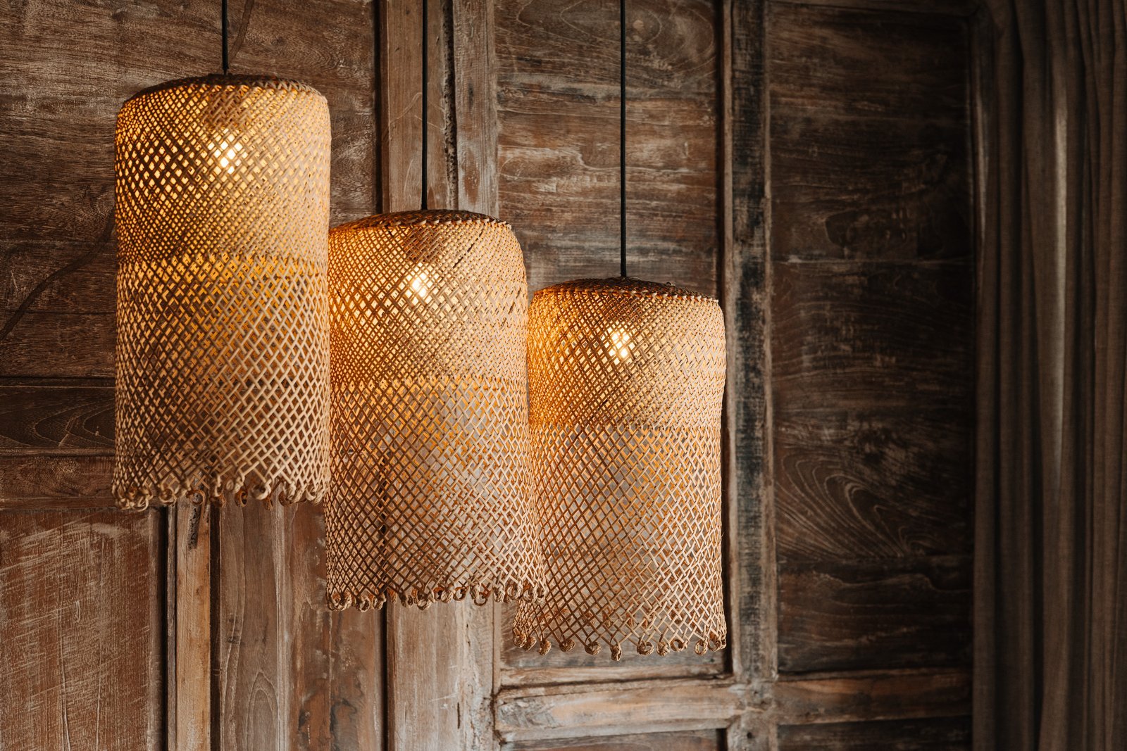 Woven rattan pendant lamps against the carved wooden walls